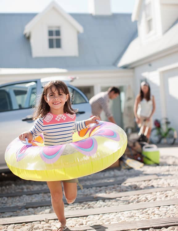 Child with inflatable swimming ring running outside vacation home in Orlando