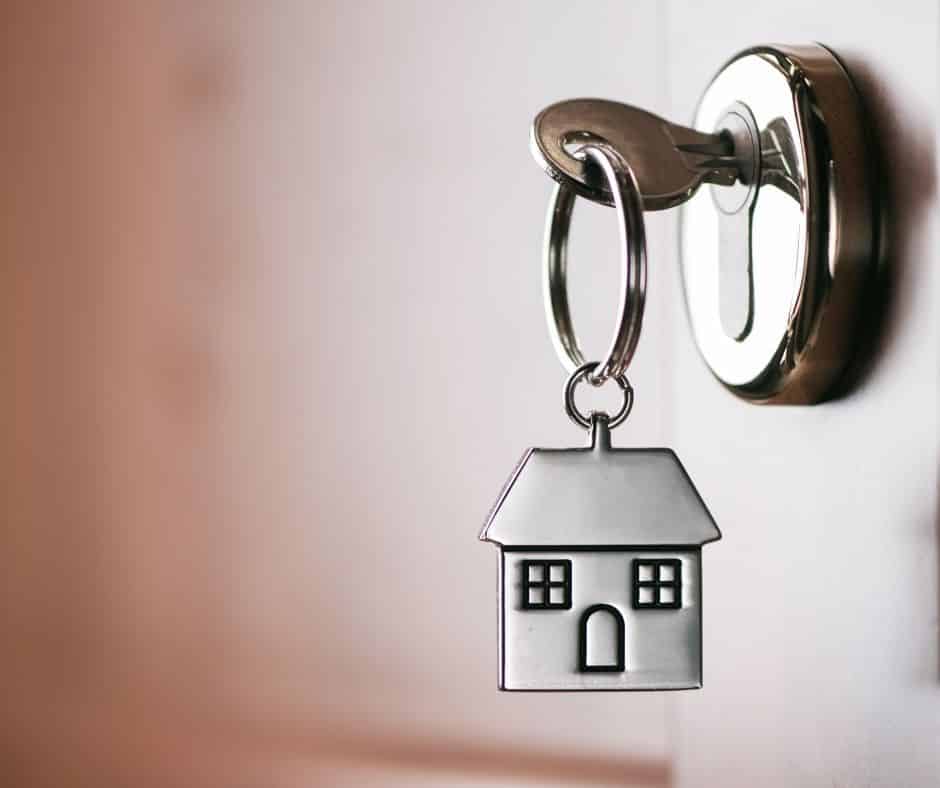 House shaped key chain with a key inserted in a door lock