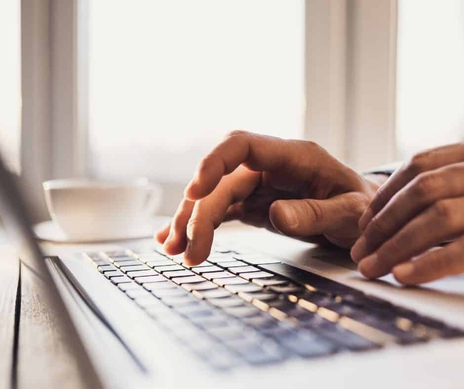 Close up view of hands typing on a laptop computer