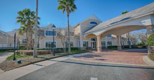 Lakes of Mount Dora Clubhouse entrance with a paver driveway